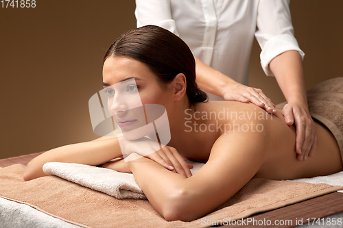 Image of woman lying and having back massage at spa