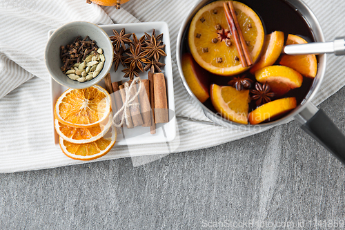 Image of pot with hot mulled wine, orange slices and spices