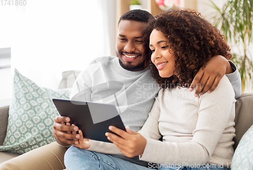 Image of african american couple with tablet pc at home