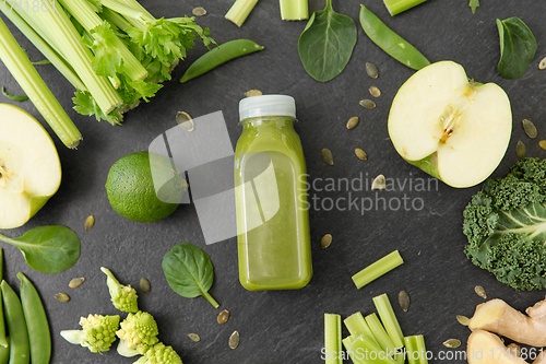 Image of close up of bottle with green juice and vegetables