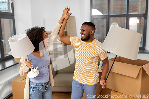 Image of happy couple packing boxes and moving to new home