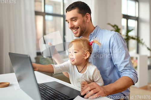 Image of working father with baby daughter at home office