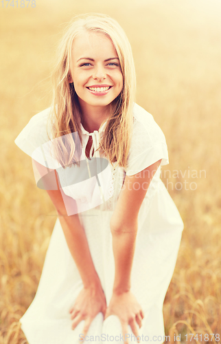 Image of smiling young woman in white dress on cereal field