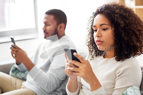 Image of african american couple with smartphone at home