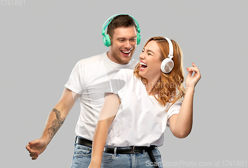 Image of happy couple in headphones dancing