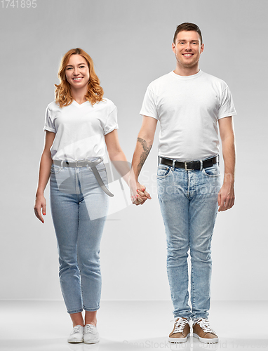 Image of happy couple in white t-shirts holding hands