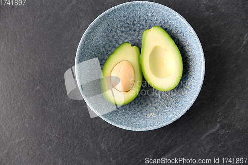 Image of close up of ripe avocado with bone in ceramic bowl