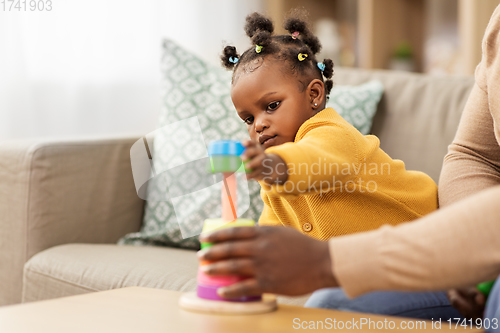 Image of african family playing with baby daughter at home