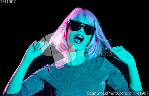 Image of happy woman in pink wig and sunglasses dancing