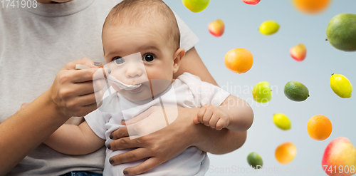 Image of close up of mother with spoon feeding little baby