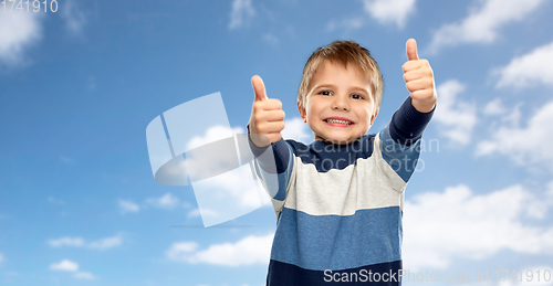 Image of little boy in striped pullover showing thumbs up