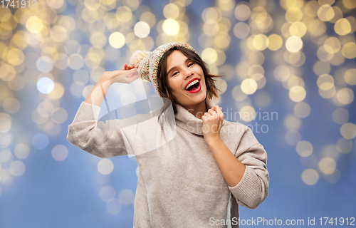 Image of young woman in winter hat and sweater on christmas