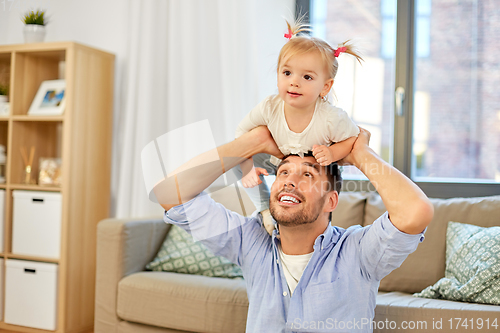 Image of father riding little baby daughter on neck at home