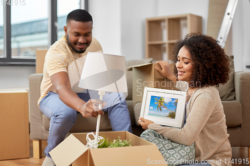 Image of happy couple packing boxes and moving to new home