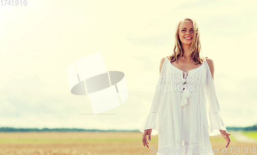 Image of smiling young woman in white dress on cereal field