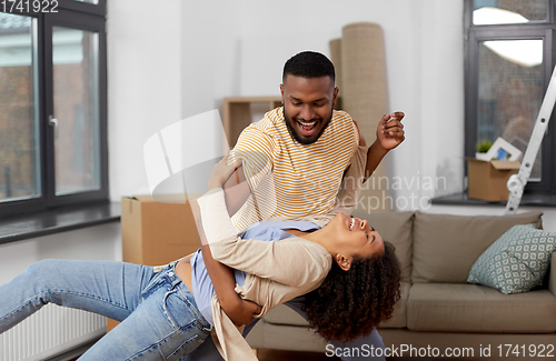 Image of happy couple moving to new home and dancing