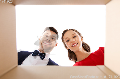 Image of happy couple looking into open christmas gift box