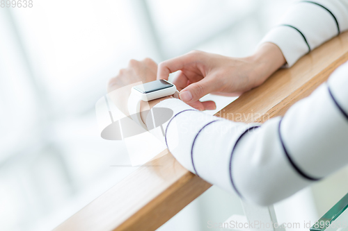 Image of Woman touch on the screen of smart watch