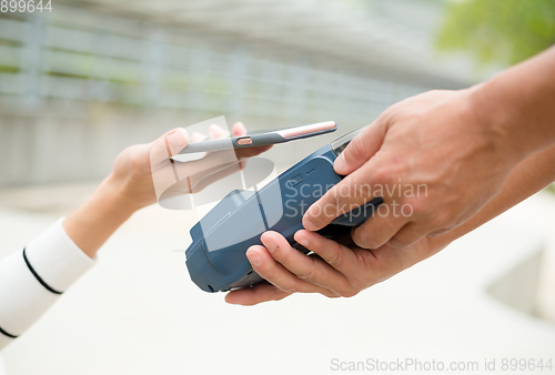 Image of Woman pay the bill with mobile phone