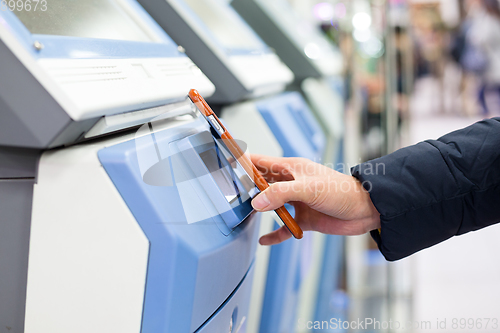 Image of Woman using mobile phone for paying on machine