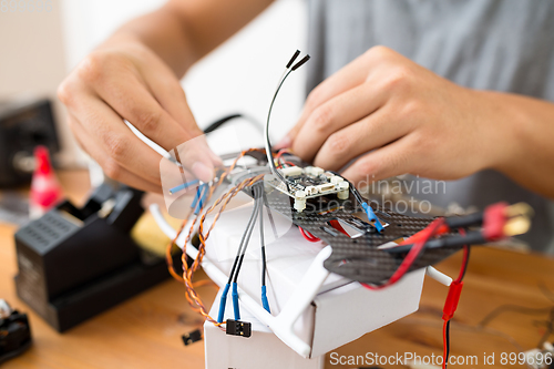 Image of Man connecting the component of the drone