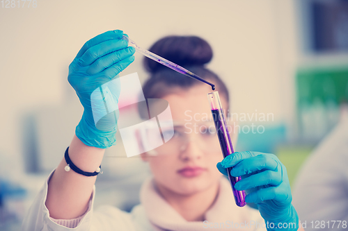 Image of female student with protective glasses making chemistry experime