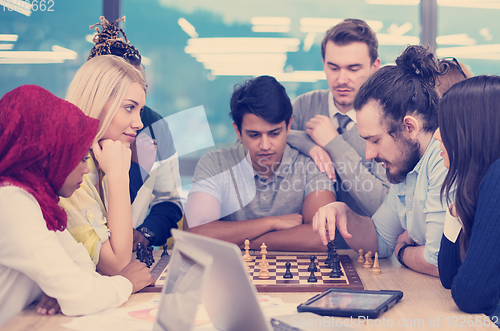 Image of multiethnic group of business people playing chess