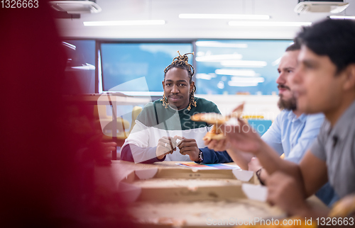 Image of multiethnic business team eating pizza