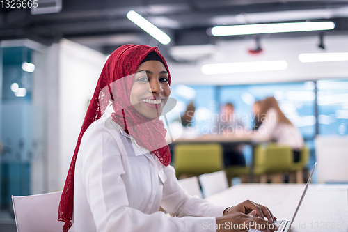 Image of black muslim business woman ,working on laptop computer