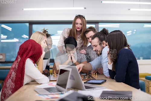 Image of multiethnic group of business people playing chess