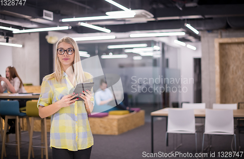 Image of blonde businesswoman working online using digital tablet