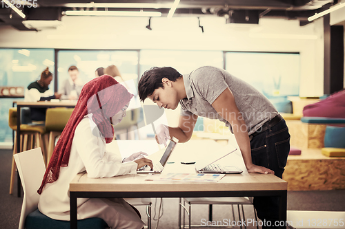 Image of black muslim business woman having a meeting with her indian mal