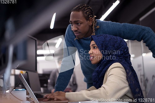 Image of young black muslim female software developer at work