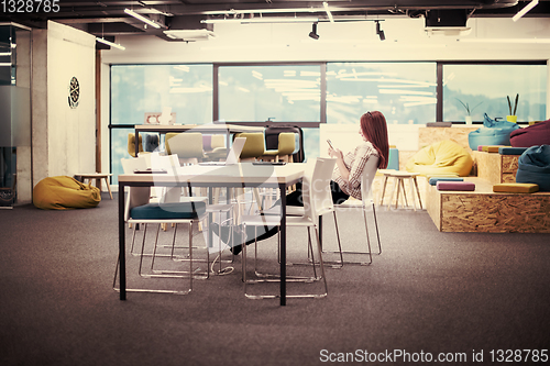 Image of redhead businesswoman using mobile phone at office