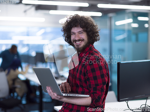 Image of smiling male software developer using laptop