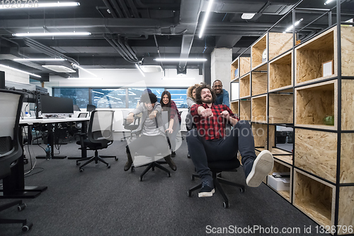 Image of multiethnics business team racing on office chairs