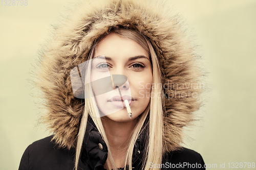 Image of portrait of young blonde girl with cigarette in the mouth