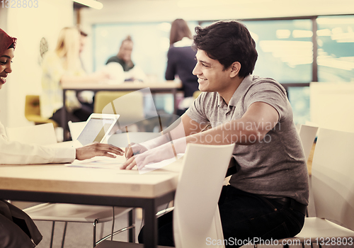 Image of black muslim business woman having a meeting with her indian mal