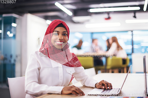 Image of black muslim business woman ,working on laptop computer