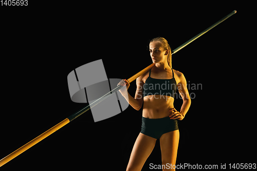 Image of Female pole vaulter training on black studio background in neon light