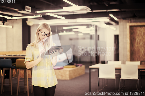 Image of blonde businesswoman working online using digital tablet