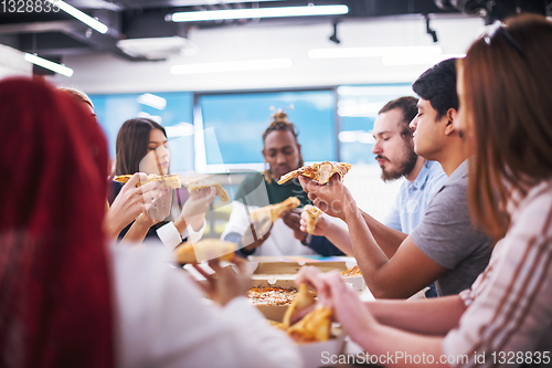 Image of multiethnic business team eating pizza