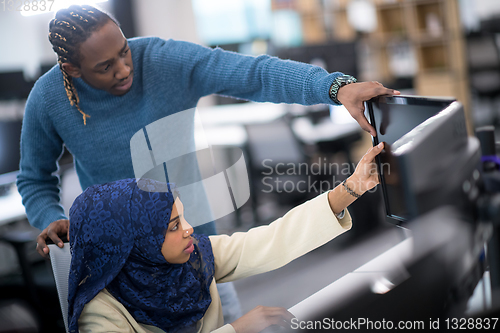 Image of young black muslim female software developer at work