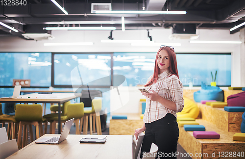 Image of redhead businesswoman using mobile phone at office