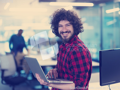 Image of smiling male software developer using laptop