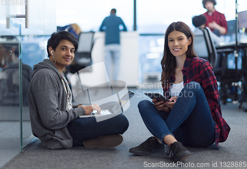 Image of young software developers couple working on the floor