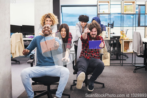 Image of multiethnics business team racing on office chairs