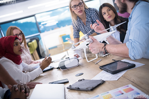 Image of multiethnic business team learning about drone technology