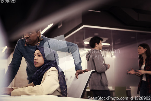 Image of young black muslim female software developer at work