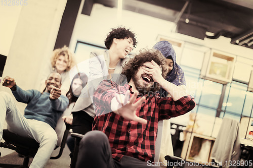 Image of multiethnics business team racing on office chairs